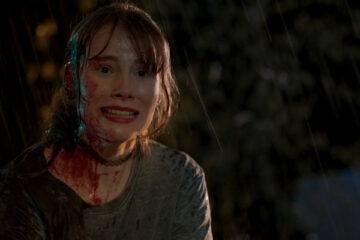 Lair 2021 Movie Scene Anya Newall as Joey all bloody screaming in the rain