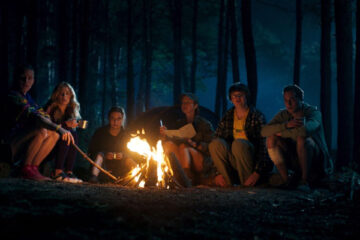 Nobody Sleeps in the Woods Tonight 2020 Movie Scene A group from the camp sitting next to a fire during the night