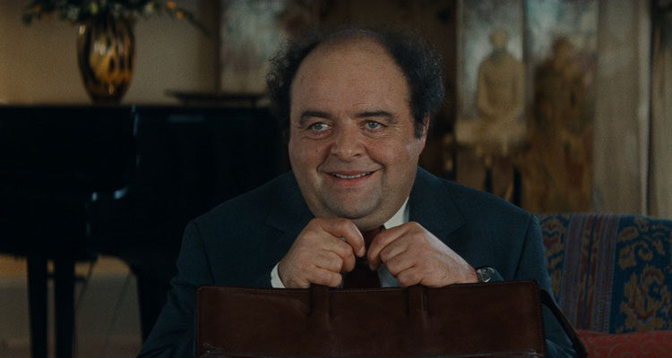 The Dinner Game 1998 Movie Scene Jacques Villeret as François Pignon holding his briefcase and smiling