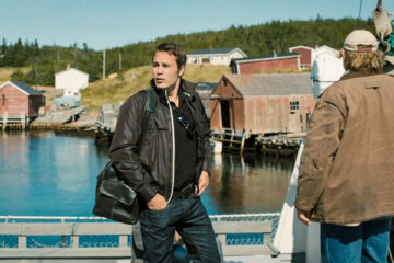 The Grand Seduction 2013 Movie Scene Taylor Kitsch as Dr. Paul Lewis arriving in Tickle Head with Brendan Gleeson as Murray French