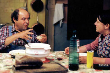 Un Crime Au Paradis 2001 Movie Scene Jacques Villeret as Jojo Braconnier and Josiane Balasko as Lulu Braconnier arguing during dinner