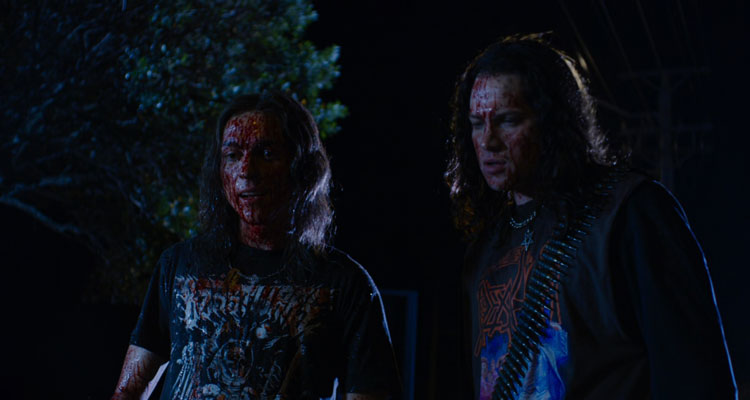 Deathgasm 2015 Movie Scene Milo Cawthorne as Brodie and James Joshua Blake as Zakk covered in blood and wearing metal t-shirts