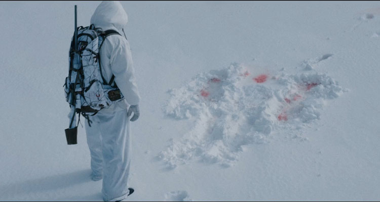 Wind River 2017 Movie Scene Jeremy Renner as Cory looking at the bloody tracks in the snow