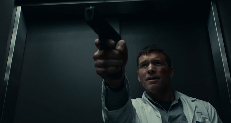 Fractured 2019 Movie Scene Sam Worthington as Ray Monroe holding a gun inside a hospital