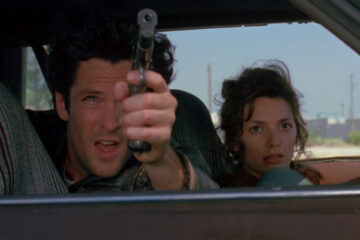 Kill Me Again 1989 Movie Scene Michael Madsen as Vince holding a gun with Joanne Whalley as Fay sitting next to him