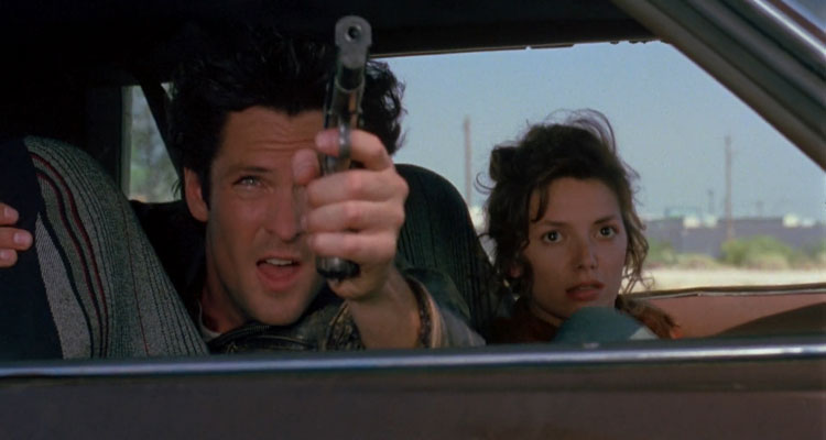 Kill Me Again 1989 Movie Scene Michael Madsen as Vince holding a gun with Joanne Whalley as Fay sitting next to him