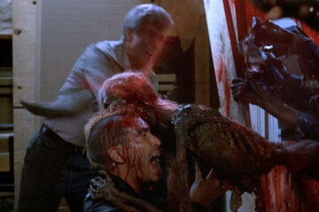 Return of the Living Dead 1985 Movie Scene A zombie eating the head of Brian Peck as Scuz with blood squirting out of it