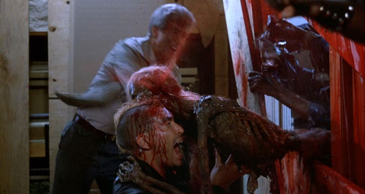 Return of the Living Dead 1985 Movie Scene A zombie eating the head of Brian Peck as Scuz with blood squirting out of it
