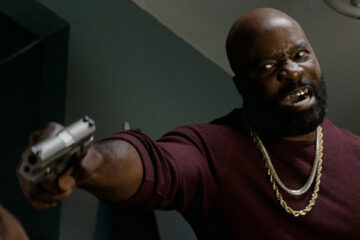 Black and Blue 2019 Movie Scene Mike Colter as Darius holding a gun to Naomie Harris as Alicia's face