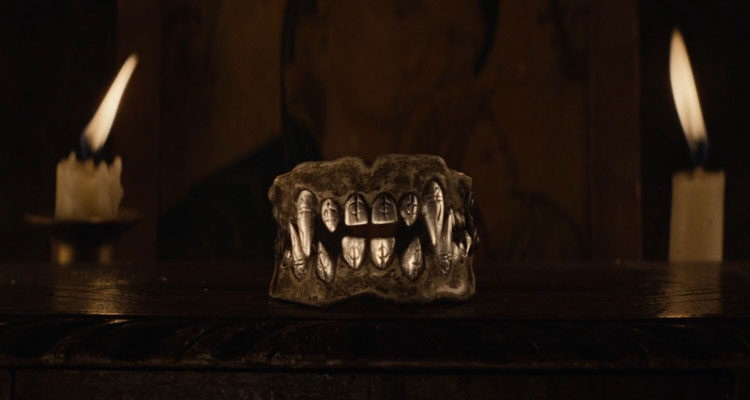 The Cursed AKA Eight for Silver 2021 Movie Scene The teeth made out of silver with two big fangs and markings on them