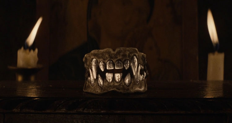The Cursed AKA Eight for Silver 2021 Movie Scene The teeth made out of silver with two big fangs and markings on them