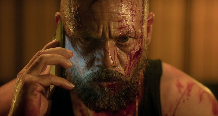 Xtremo AKA Xtreme 2021 Movie Scene Teo García as Max all bloody making a phone call and grunting