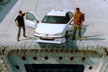Taxi 1998 Movie Scene Samy Naceri as Daniel and Frederic Diefenthal as Emilien standing at the edge of unfinished bridge next to their car