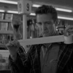 In Cold Blood Movie 1967 Scene Scott Wilson as Dick Hickock holding a duct tape in a store before the robbery and winking