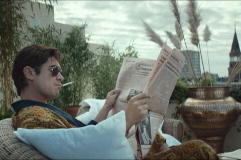 Lo Spietato AKA The Ruthless Movie 2019 Scene Riccardo Scamarcio as Santo Russo reading the newspapers and smoking a cigarette in his loft