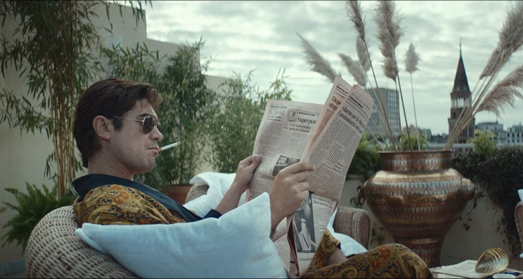 Lo Spietato AKA The Ruthless Movie 2019 Scene Riccardo Scamarcio as Santo Russo reading the newspapers and smoking a cigarette in his loft