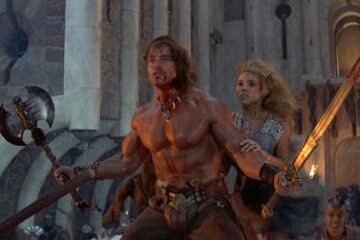Conan The Destroyer 1984 Movie Scene Arnold Schwarzenegger as Conan holding a sword and an axe protecting Olivia d'Abo as Princess Jehnna