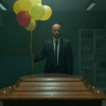 Restless Movie 2022 Scene Franck Gastambide as Thomas holding a bunch of balloons in front of a coffin