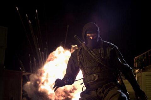 Ninja 2 Shadow of a Tear 2013 Movie Scene Scott Adkins as Casey dressed as ninja with an explosion going off behind him
