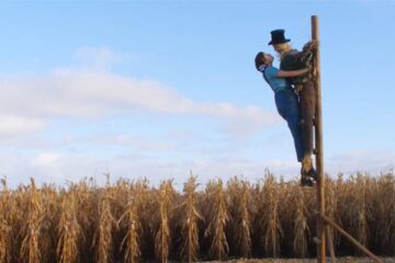 Pearl 2022 Movie Scene Mia Goth as Pearl in a cornfield kissing scarecrow