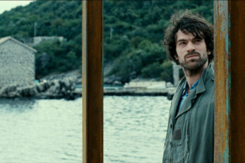 The Big Picture 2010 Movie Scene Romain Duris as Paul Exben at the dock in a small coastal town in Montenegro