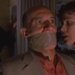 Death and the Maiden 1994 Movie Scene Sigourney Weaver as Paulina talking to Ben Kingsley as Dr. Roberto Miranda who's gagged and bound to a chair