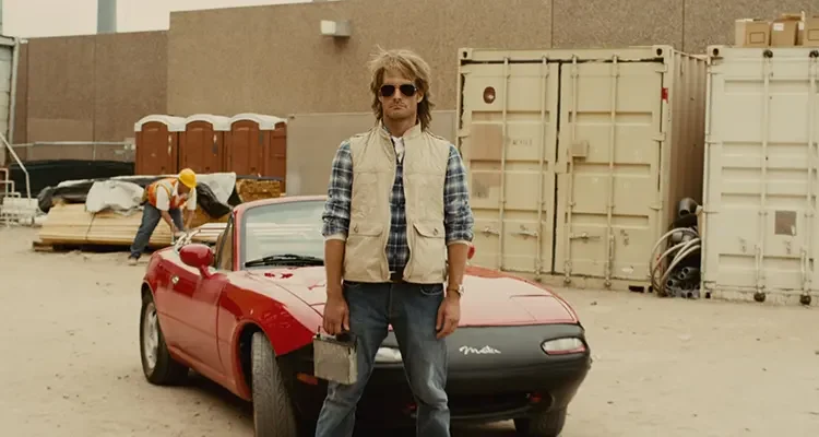 MacGruber 2010 Movie Scene Will Forte as MacGruber holding his car stereo in front of his car, red Mazda Miata