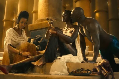 Three Thousand Years of Longing 2022 Movie Scene Idris Elba as The Djinn talking to Aamito Lagum as The Queen of Sheba shaving her legs