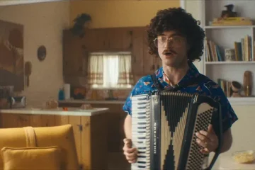Weird The Al Yankovic Story 2022 Movie Scene Daniel Radcliffe as Weird Al in a Hawaiian shirt and playing an accordion