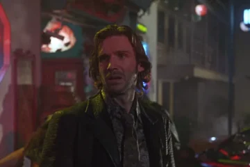 Strange Days 1995 Movie Scene Ralph Fiennes as Lenny Nero outside a seedy bar in back alley with a neon light behind him