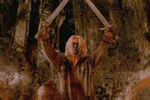 Brotherhood Of The Wolf 2001 Movie Scene Samuel Le Bihan as Grégoire de Fronsac holding two swords with his face painted