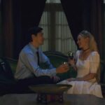 House of Darkness 2022 Movie Scene Kate Bosworth as Mina and Justin Long as Hap talking and drinking in her mansion