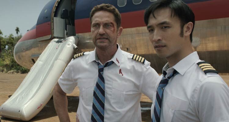 Plane 2023 Movie Scene Gerard Butler as Brodie Torrance and Yoson An as Samuel Dele standing in front of a plane that's just crash landed in the jungle
