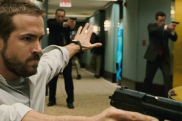 Smokin Aces 2006 Movie Scene Ryan Reynolds as Messner holding a gun during a shootout in the hotel and showing other FBI officers to hold