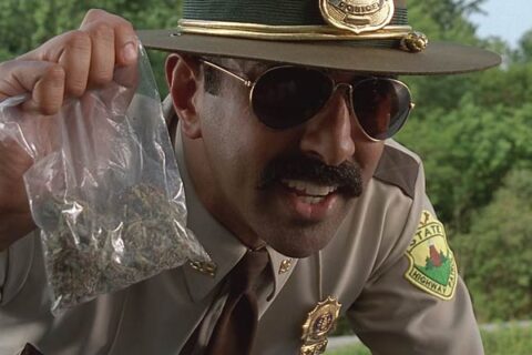 Super Troopers 2001 Movie Scene Jay Chandrasekhar as Ramathorn holding a bag of weed after he pulled over three teenagers in a car