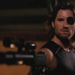 Escape From New York 1981 Movie Scene Kurt Russell as Snake Plissken wearing an eye patch and holding an Uzi with a silencer and a scope