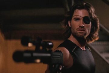 Escape From New York 1981 Movie Scene Kurt Russell as Snake Plissken wearing an eye patch and holding an Uzi with a silencer and a scope