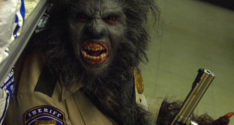 WolfCop 2014 Movie Scene Leo Fafard as Lou Garou turned into a werewolf holding a gun and wearing a police uniform during the robbery of the store