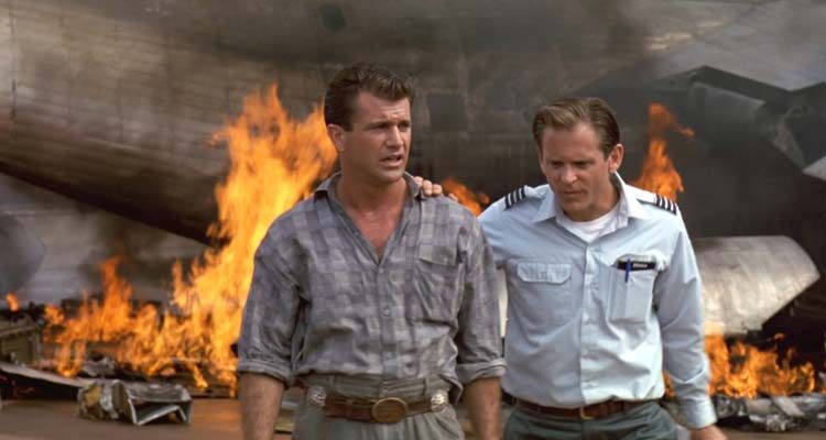 Air America 1990 Movie Scene Mel Gibson as Gene walking away from a burning wreck of an airplane with David Marshall Grant as Rob Diehl