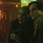 Renfield 2023 Movie Scene Nicholas Hoult as Renfield and Nicolas Cage as Dracula talking in his lair while he's drinking blood