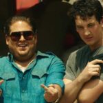 War Dogs 2016 Movie Scene Jonah Hill as Efraim Diveroli and Miles Teller as David Packouz posing for a picture in front of a truck after a successful delivery of weapons