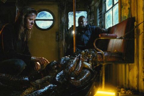 Mimic 1997 Movie Scene Mira Sorvino as Susan Tyler looking at the dead giant cockroach with Charles S. Dutton as Leonard shining a light on her