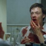 Next Door AKA Naboer 2005 Movie Scene Kristoffer Joner as John looking at his bloody face in the mirror