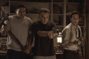 Infestation 2009 Movie Scene Ray Wise as Ethan shocking the spider with a stun gun while Christopher Marquette as Cooper and E. Quincy Sloan as Hugo are watching