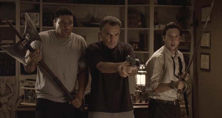 Infestation 2009 Movie Scene Ray Wise as Ethan shocking the spider with a stun gun while Christopher Marquette as Cooper and E. Quincy Sloan as Hugo are watching
