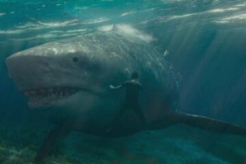 Meg 2 The Trench 2023 Movie Scene A giant megalodon shark swimming right past Jing Wu as Jiuming Zhang