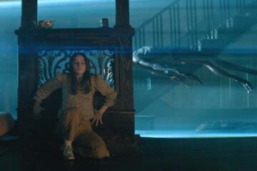 No One Will Save You 2023 Movie Scene Kaitlyn Dever as Brynn hiding from the aliens in her house while they use a tractor beam to collect the one she killed