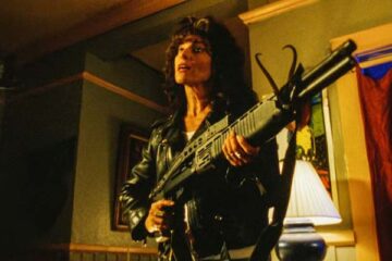 The Convent 2000 Movie Scene Adrienne Barbeau as Christine wearing jeans and a leather jacket and holding a shotgun