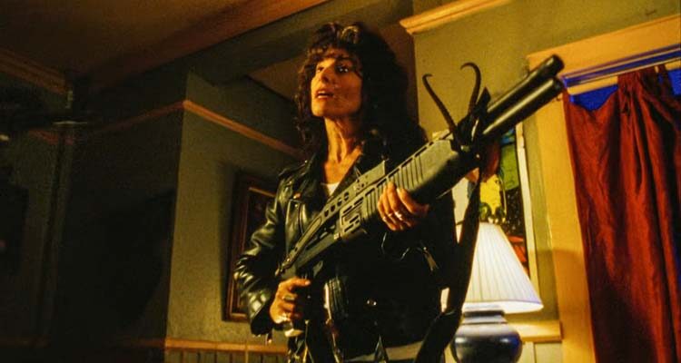 The Convent 2000 Movie Scene Adrienne Barbeau as Christine wearing jeans and a leather jacket and holding a shotgun