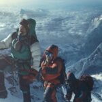 Everest 2015 Movie Scene Climbers slowly reaching the top of Mount Everest with clouds and lower mountain peaks below them